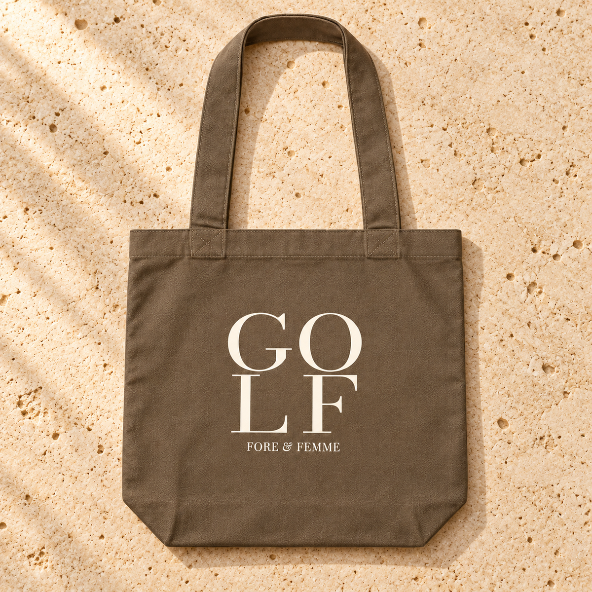 The Clubhouse Tote flat lay, a walnut canvas golf tote with GOLF wordmark print and golf accessories by Fore & Femme
