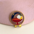 Last Round cocktail golf ball marker by Fore & Femme clipped to a pink linen cap
