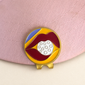 Lip Service golf ball marker by Fore & Femme clipped to a pink linen cap