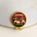 The Shortcut golf cart ball marker by Fore & Femme clipped to a cream linen cap