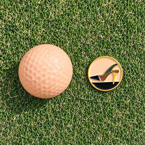 The Tee Heel golf ball marker by Fore & Femme on the putting green